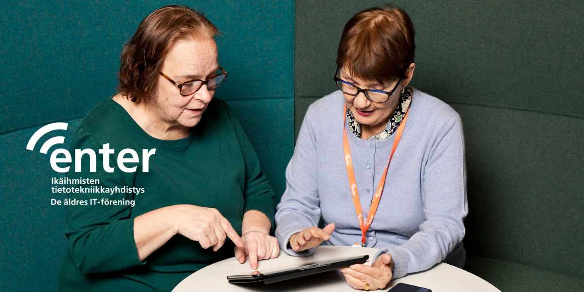 Kaksi senioria keskustelee tabletista.